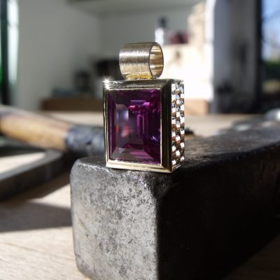 Large rectangular amethyst set in a yellow gold rectangular pendant with checkered pattern. By Marcus Ó Broin Jewellery, Kelowna, BC