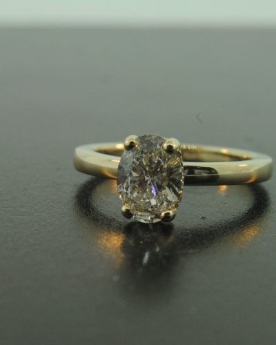 Claw set yellow gold engagement ring with accent diamonds under the head By Marcus Ó Broin Jewellery, Kelowna, BC.